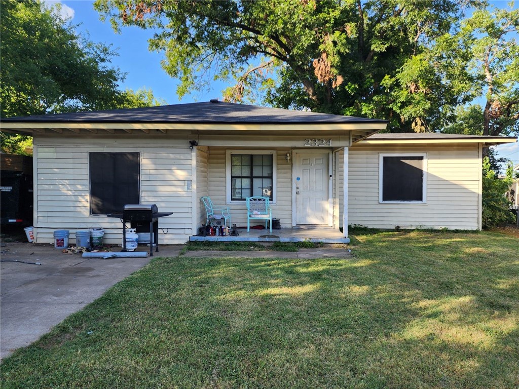 a front view of house with yard and trees in the background