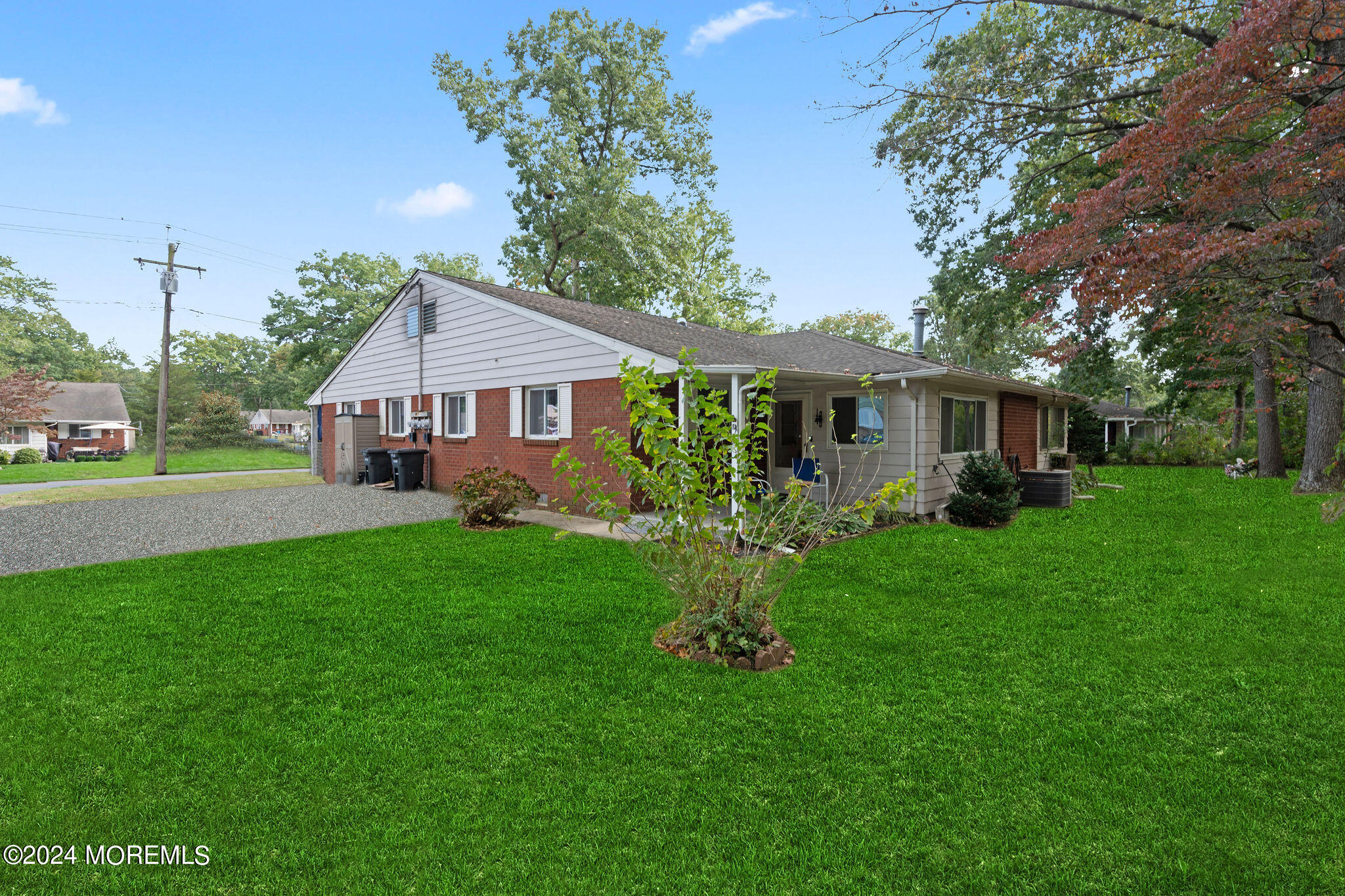 a front view of a house with a yard and green space