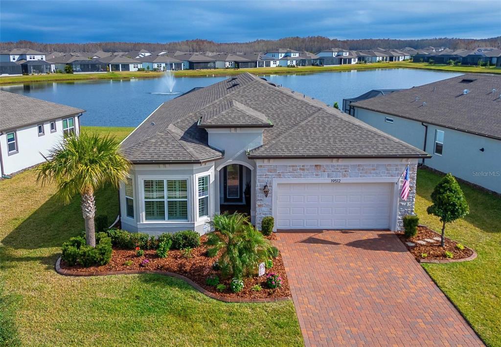 an aerial view of a house with a yard and lake view