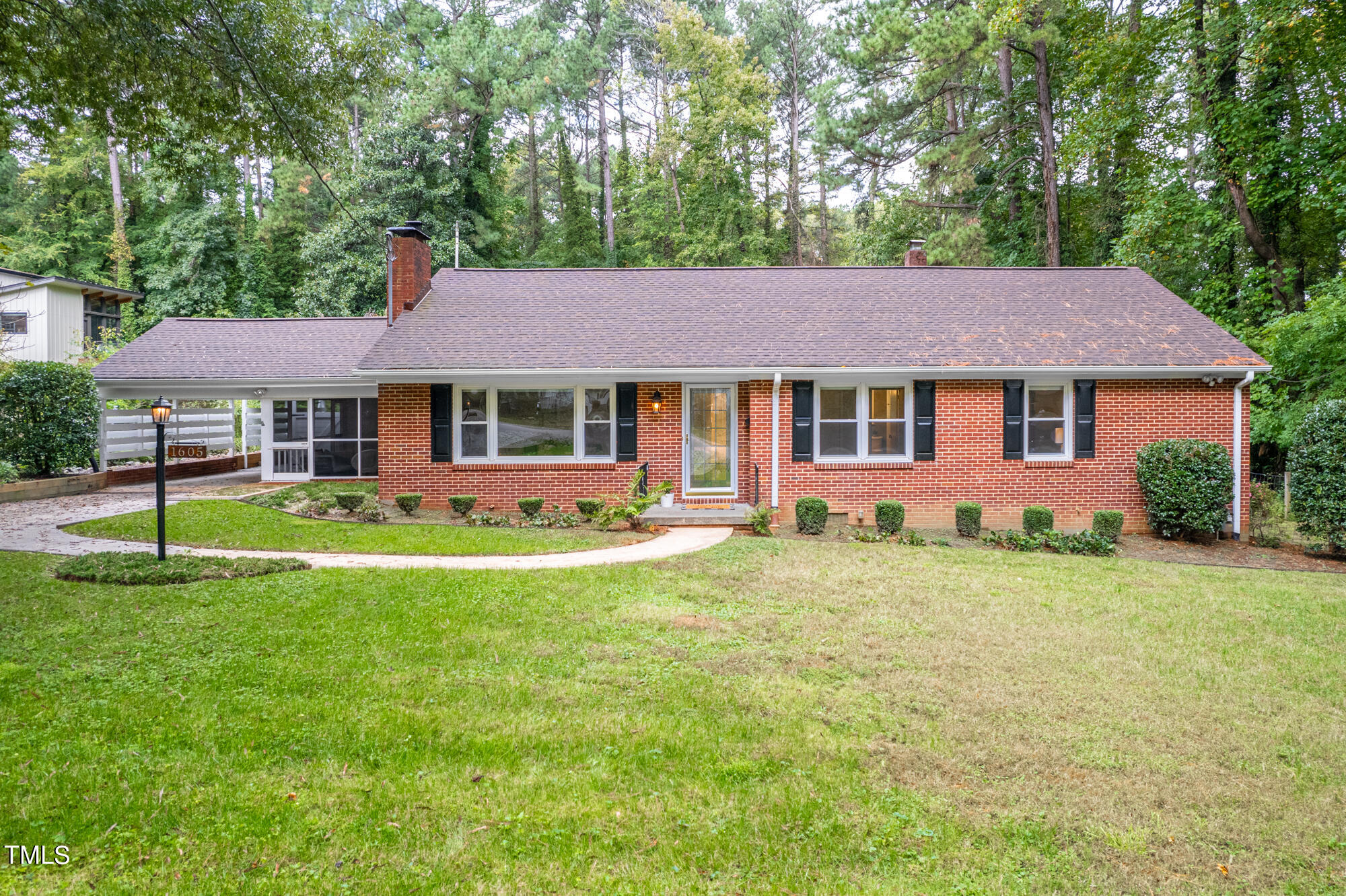 a front view of a house with a garden and trees