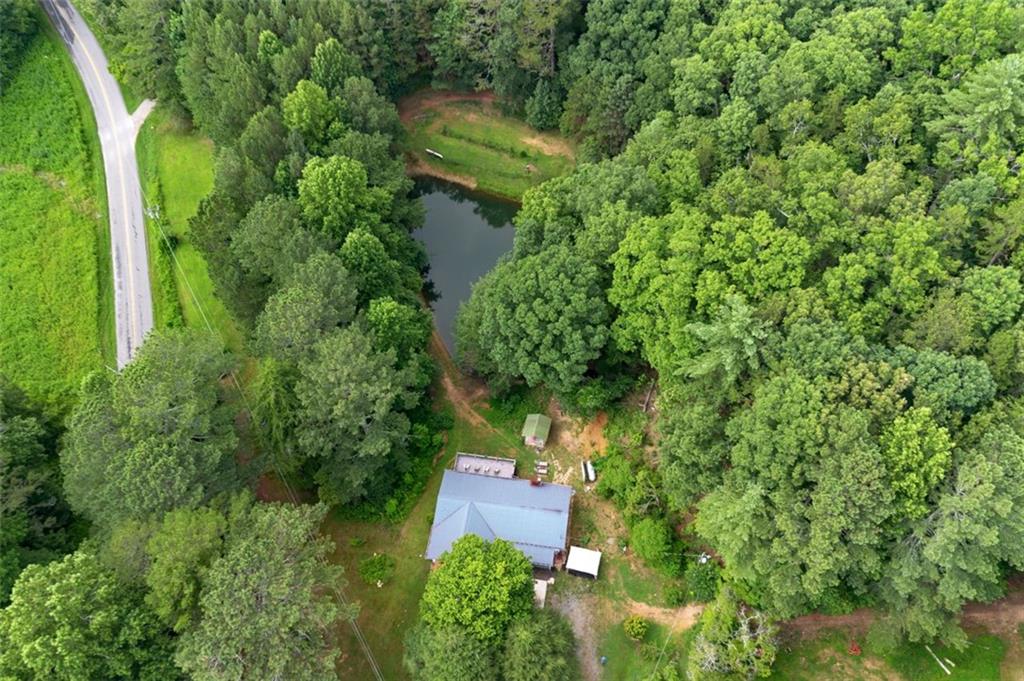 an aerial view of residential house with outdoor space and trees all around