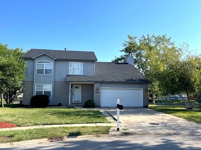 a view of a house with a yard and large tree