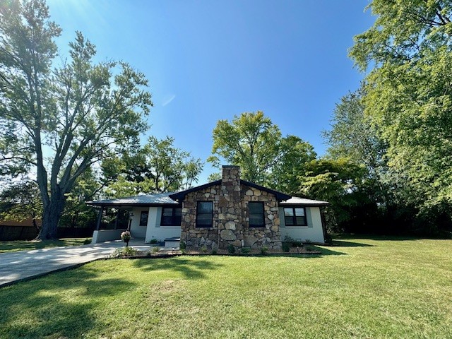 a front view of a house with a garden and trees