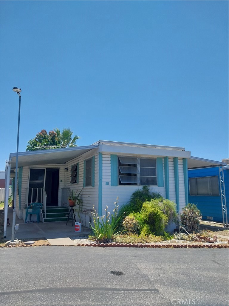 a front view of a house with a yard and potted plants