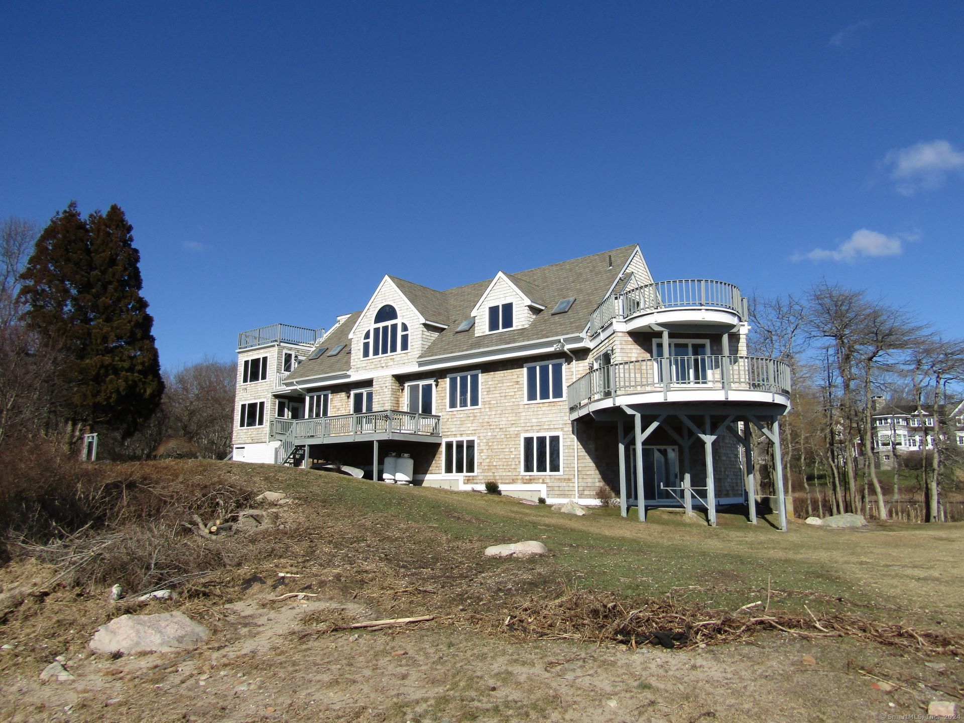 a view of a big house with a big yard and large trees