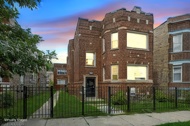 front view of a brick house with a clock tower in middle