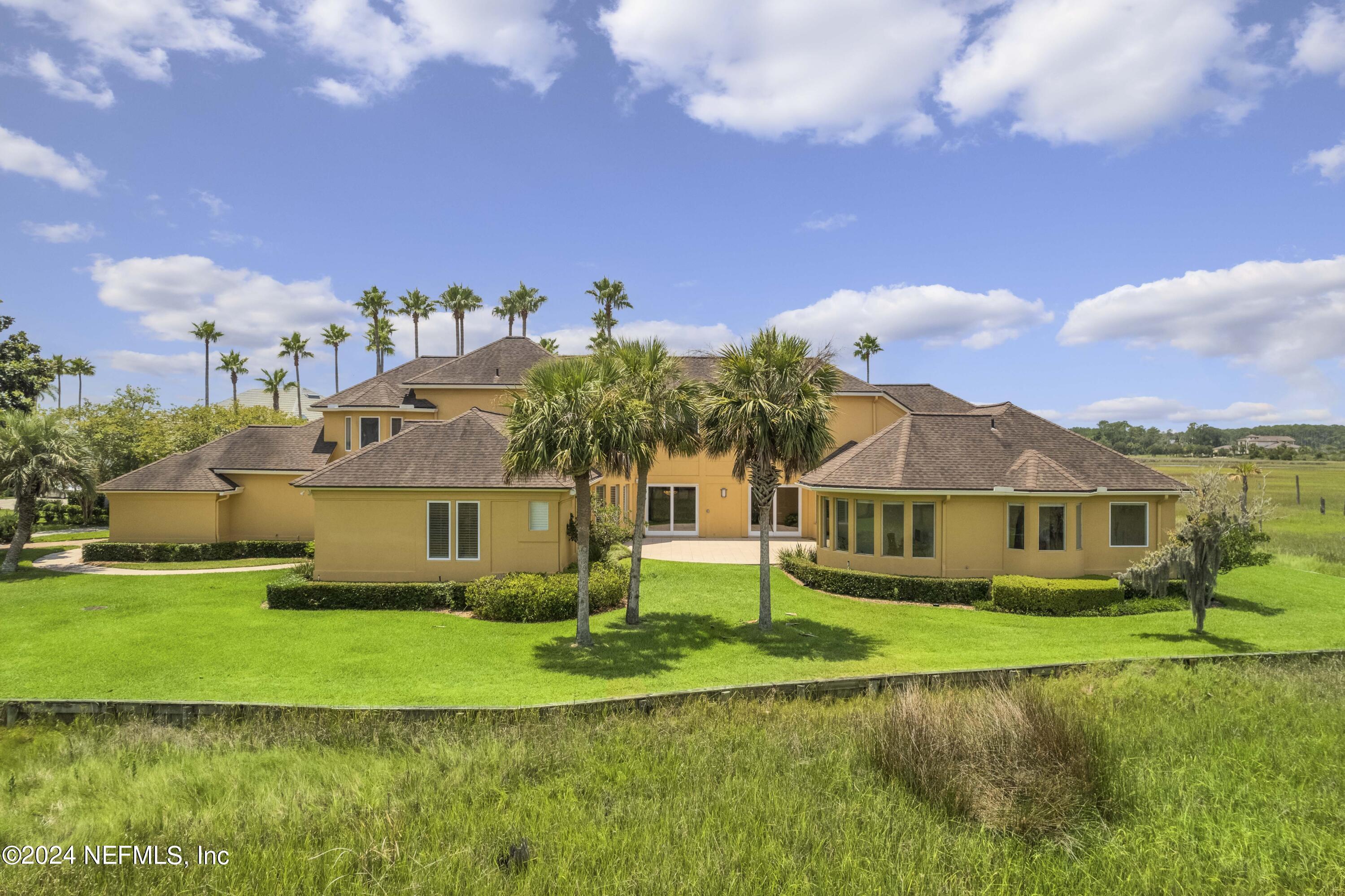 a front view of a house with a yard and lake view