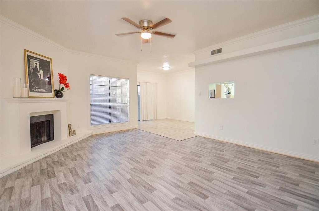 an empty room with windows and fireplace