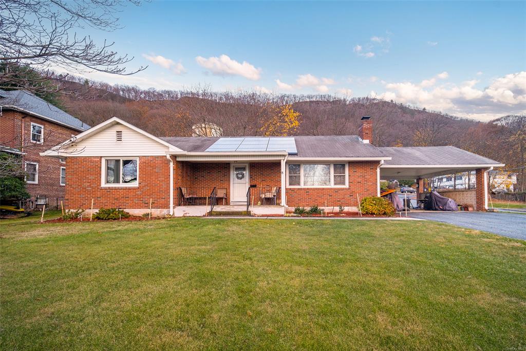 Single story home with a front yard, a mountain view, and a carport