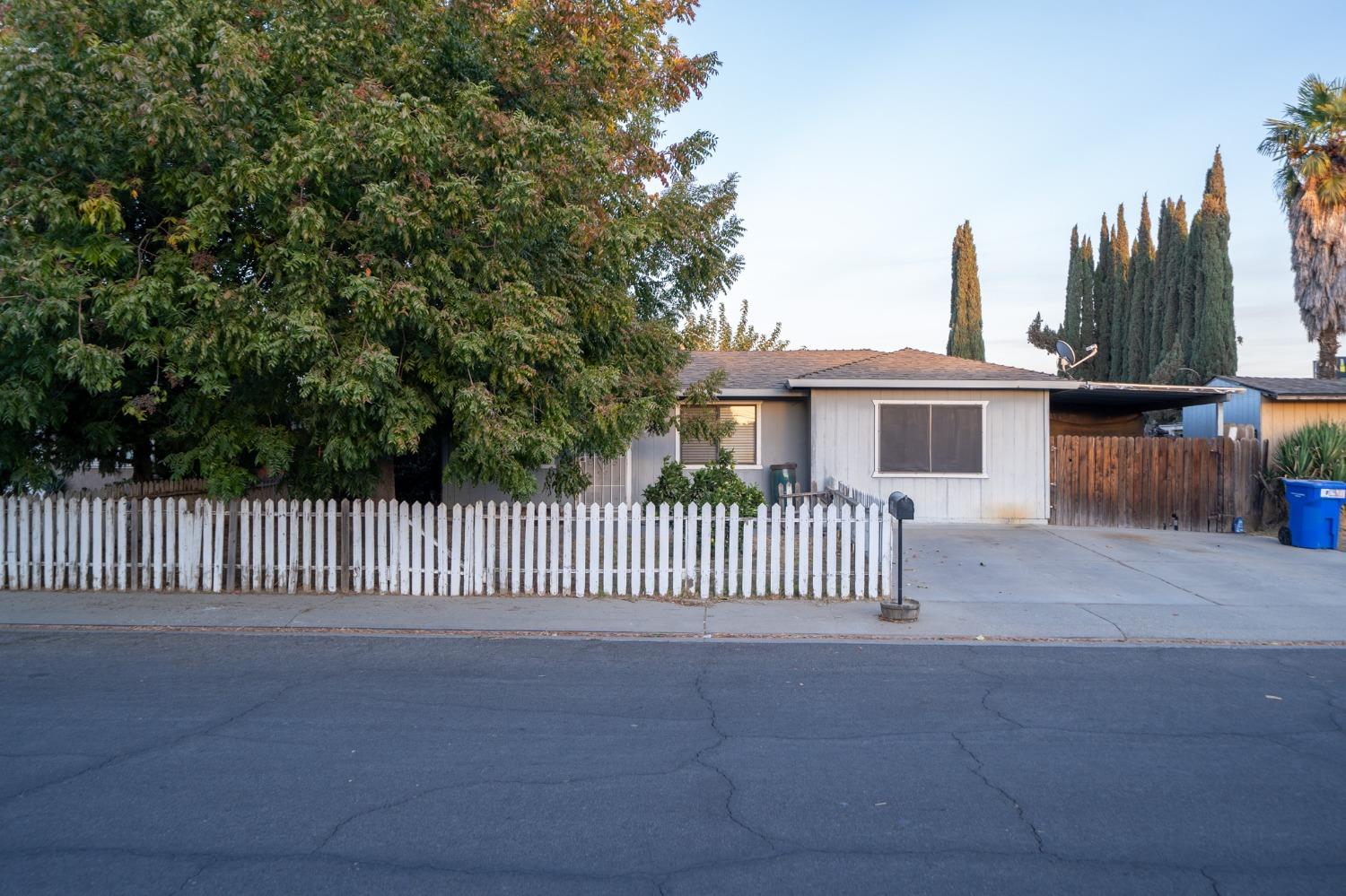 a view of a house with a fence and a yard