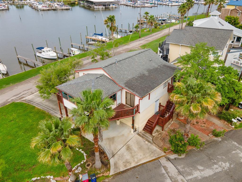 an aerial view of a house with a yard and lake view