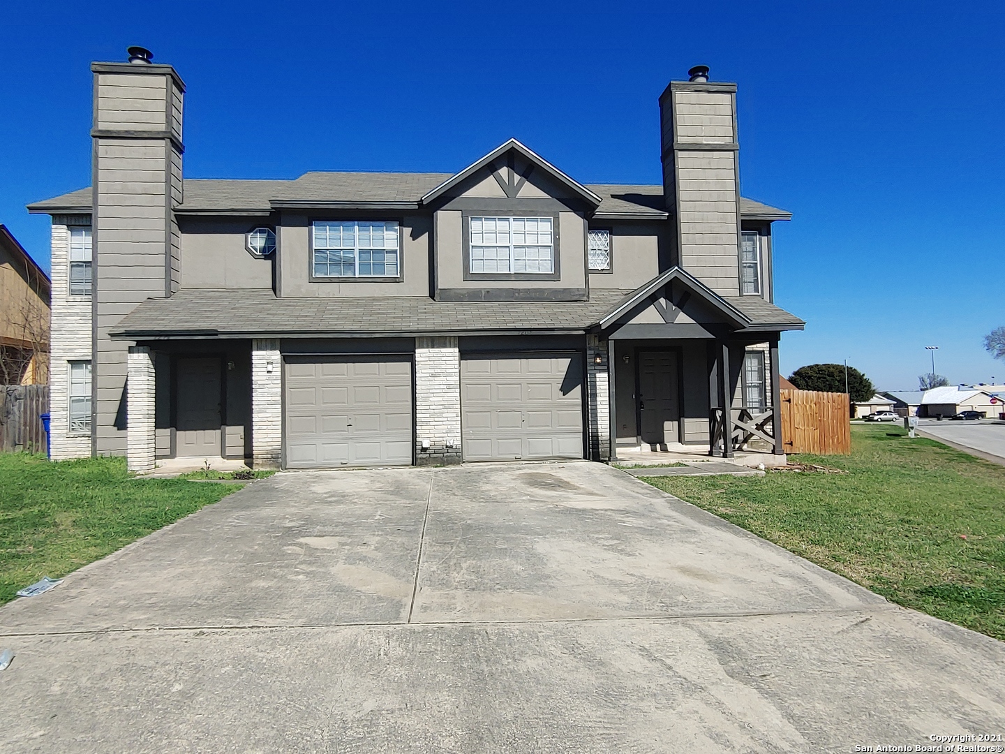 a front view of a house with a garden and garage