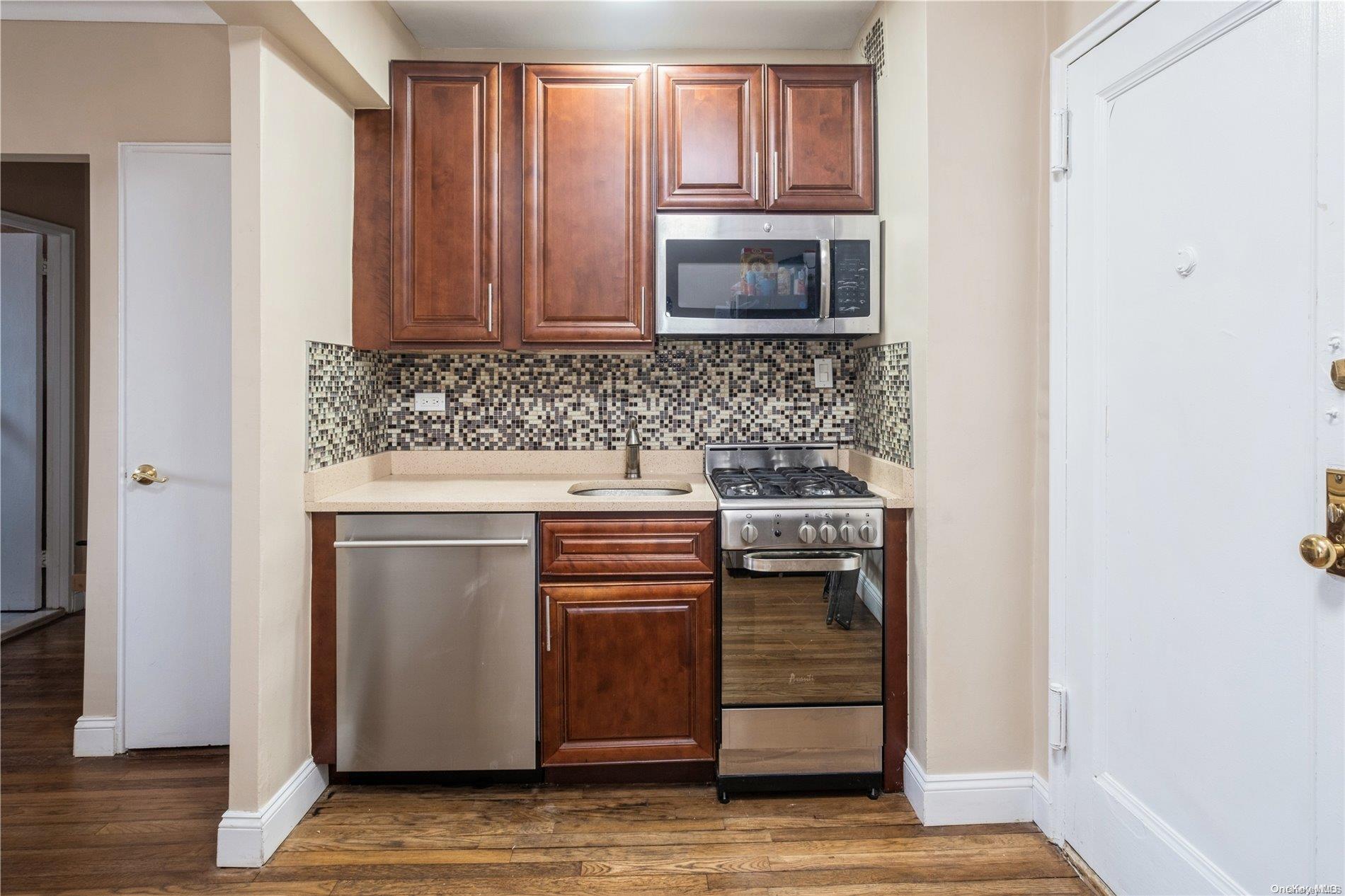 a kitchen with granite countertop white cabinets and stainless steel appliances