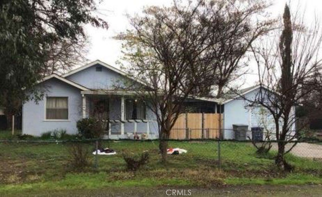 a front view of a house with a yard and trees