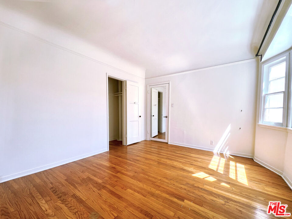 a view of empty room with wooden floor