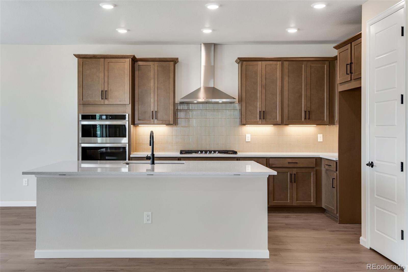 a large kitchen with stainless steel appliances granite countertop a stove and a refrigerator