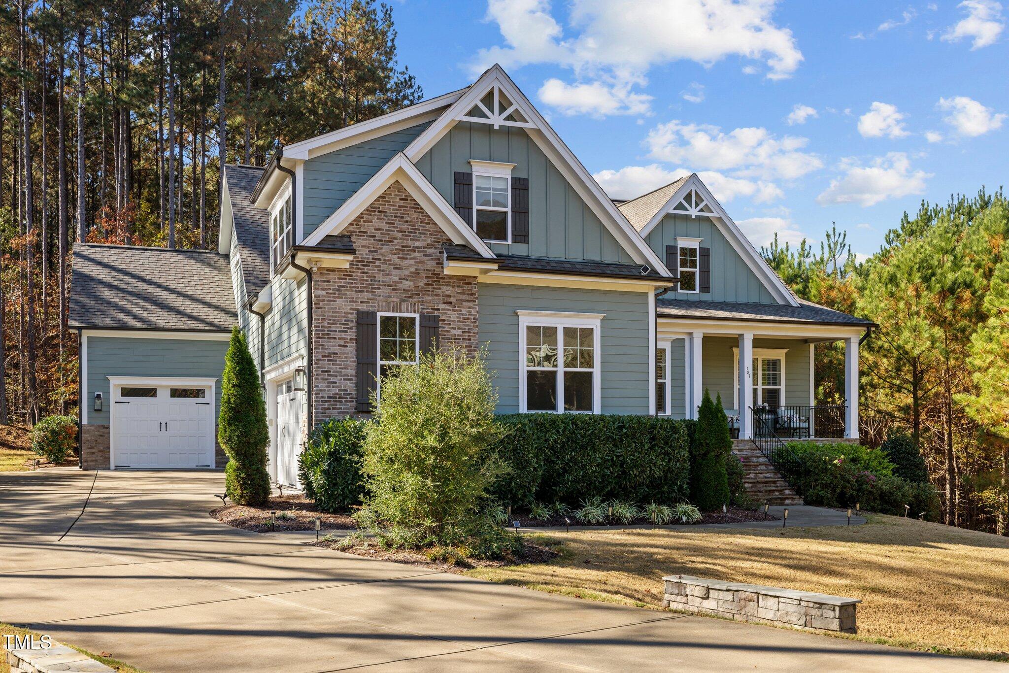 a front view of a house with a yard and trees