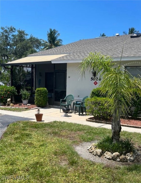 a view of a house with backyard and sitting area