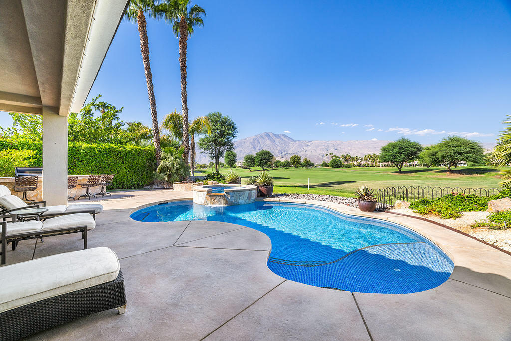 a view of a swimming pool with a lounge chair and swimming pool