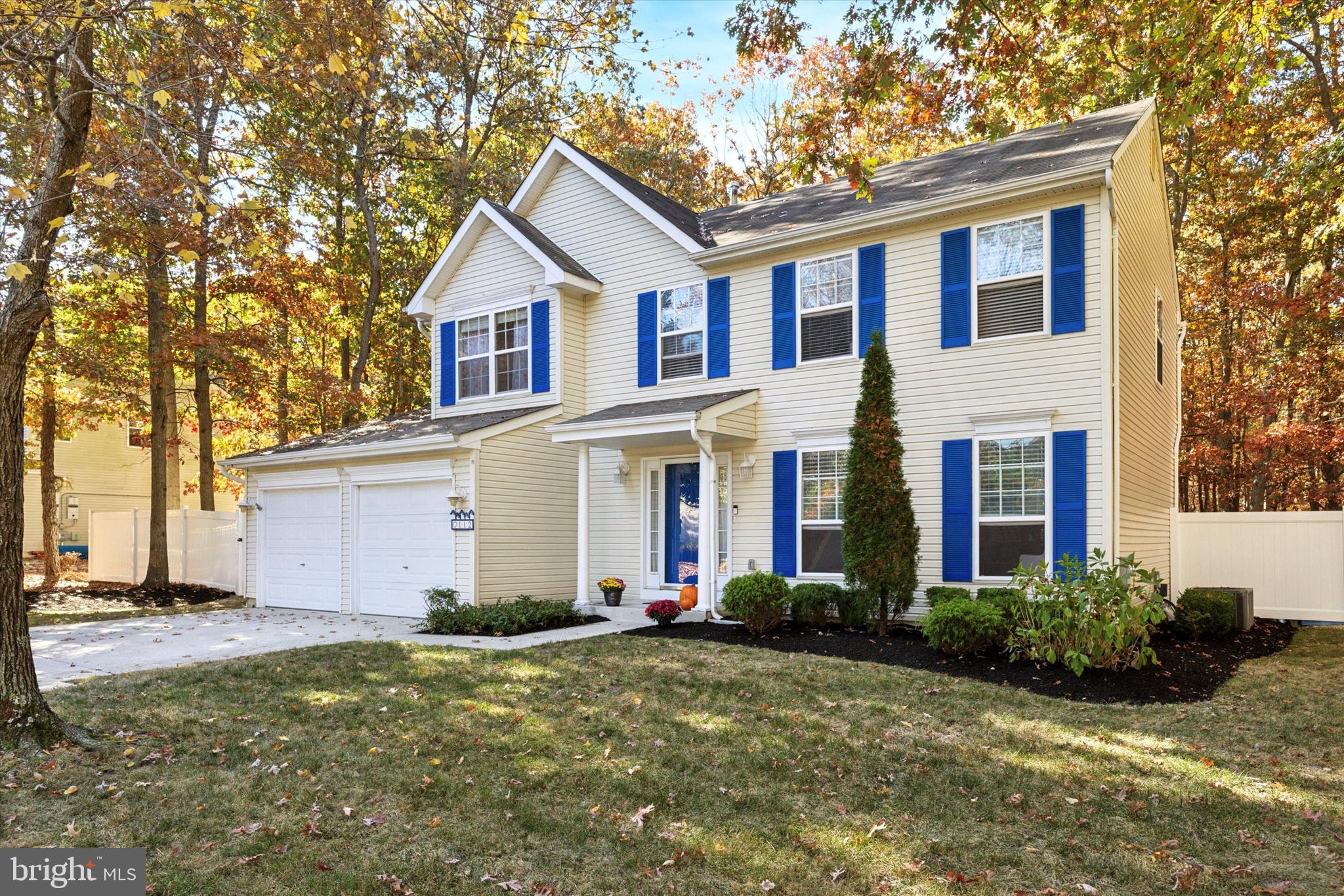 a view of a yard in front of a house with large windows