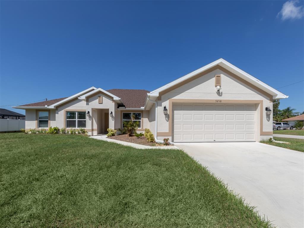 a front view of a house with a yard and garage