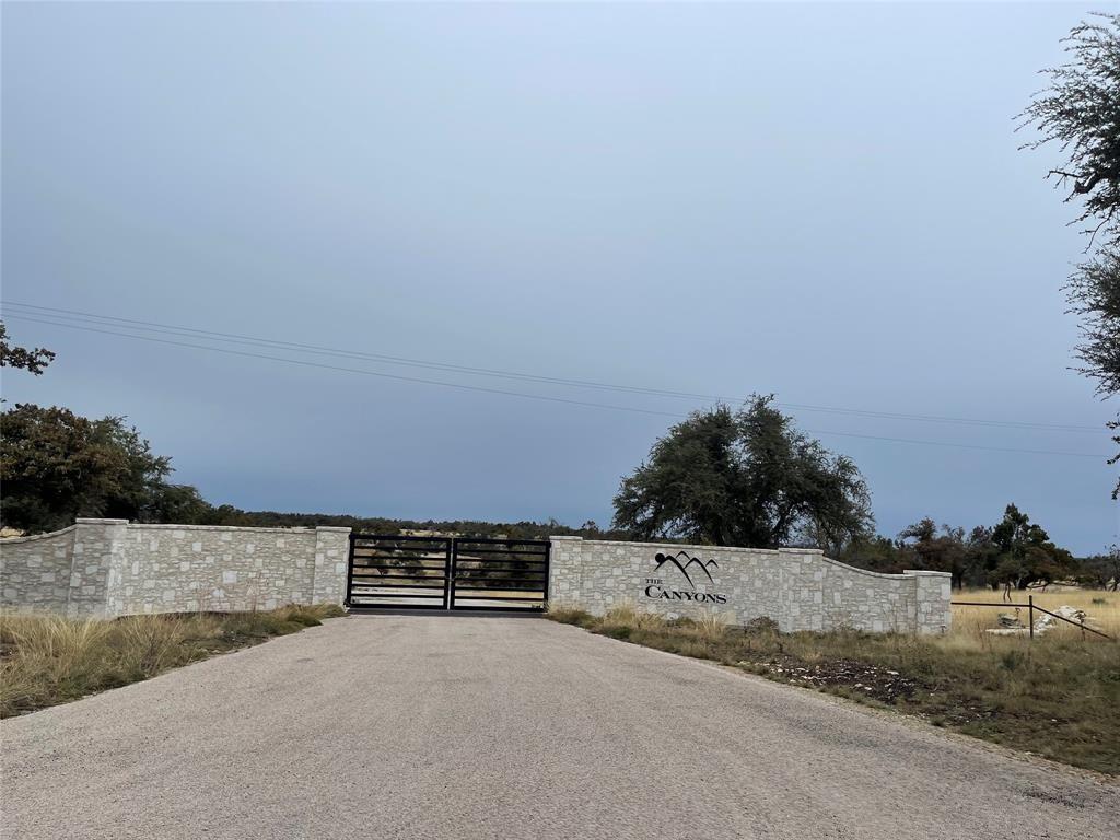 a view of a dry yard with wooden fence