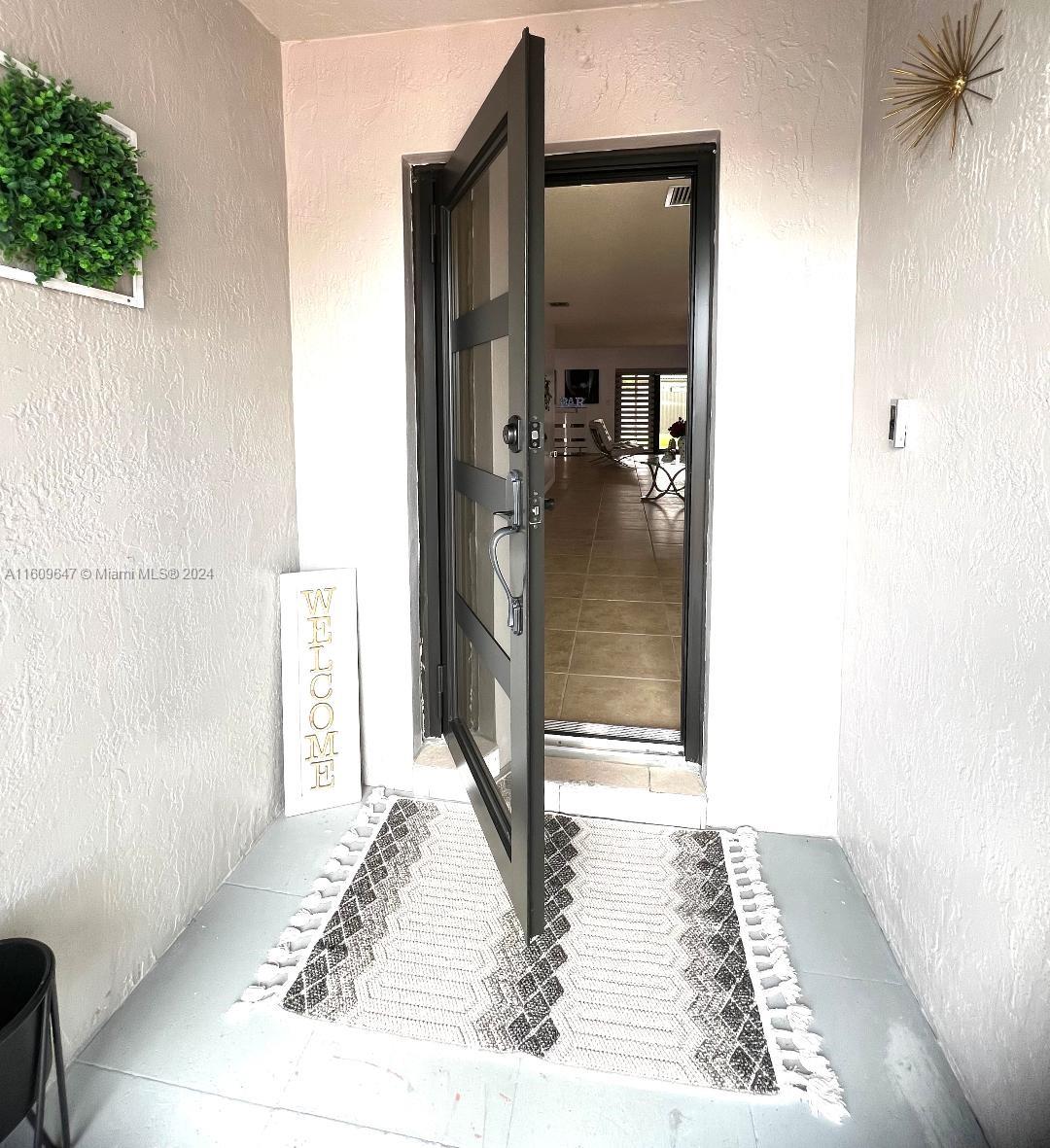 a view of a hallway with wooden floor and a living room