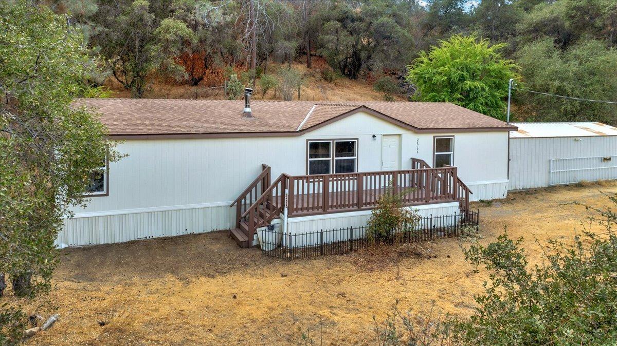 a view of a house with a wooden deck and a yard