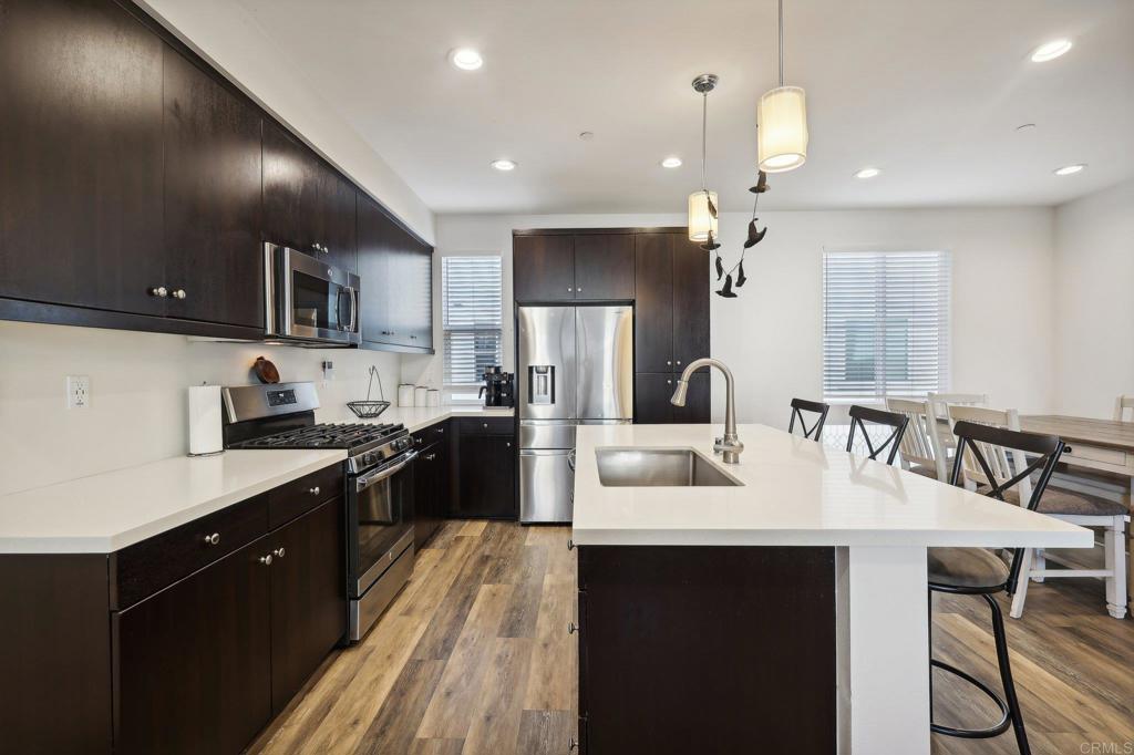 a large kitchen with kitchen island a sink a counter space and stainless steel appliances