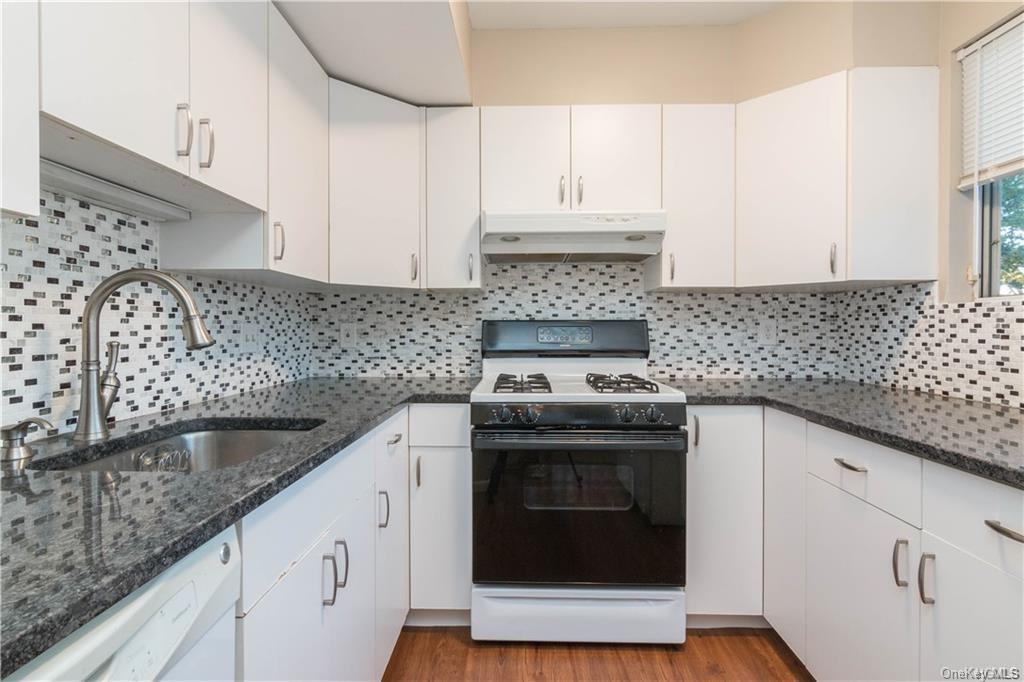 a kitchen with stainless steel appliances granite countertop a sink stove and cabinets