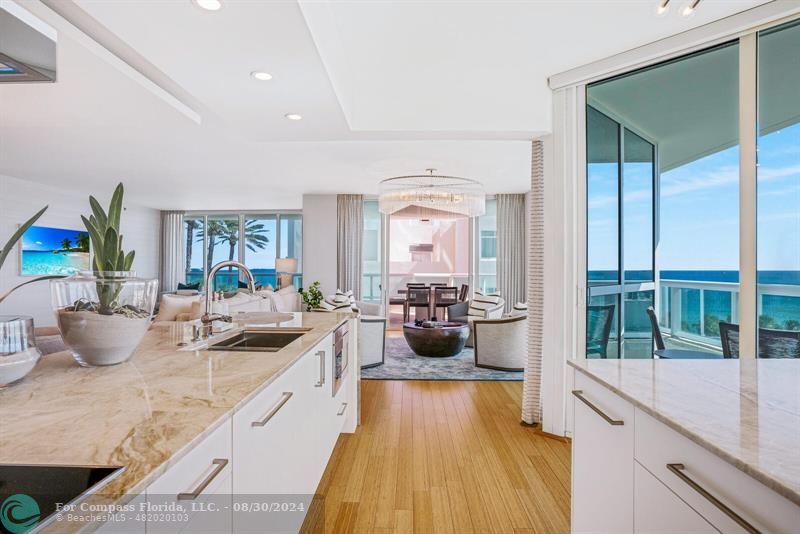 a large white kitchen with sink and a large window