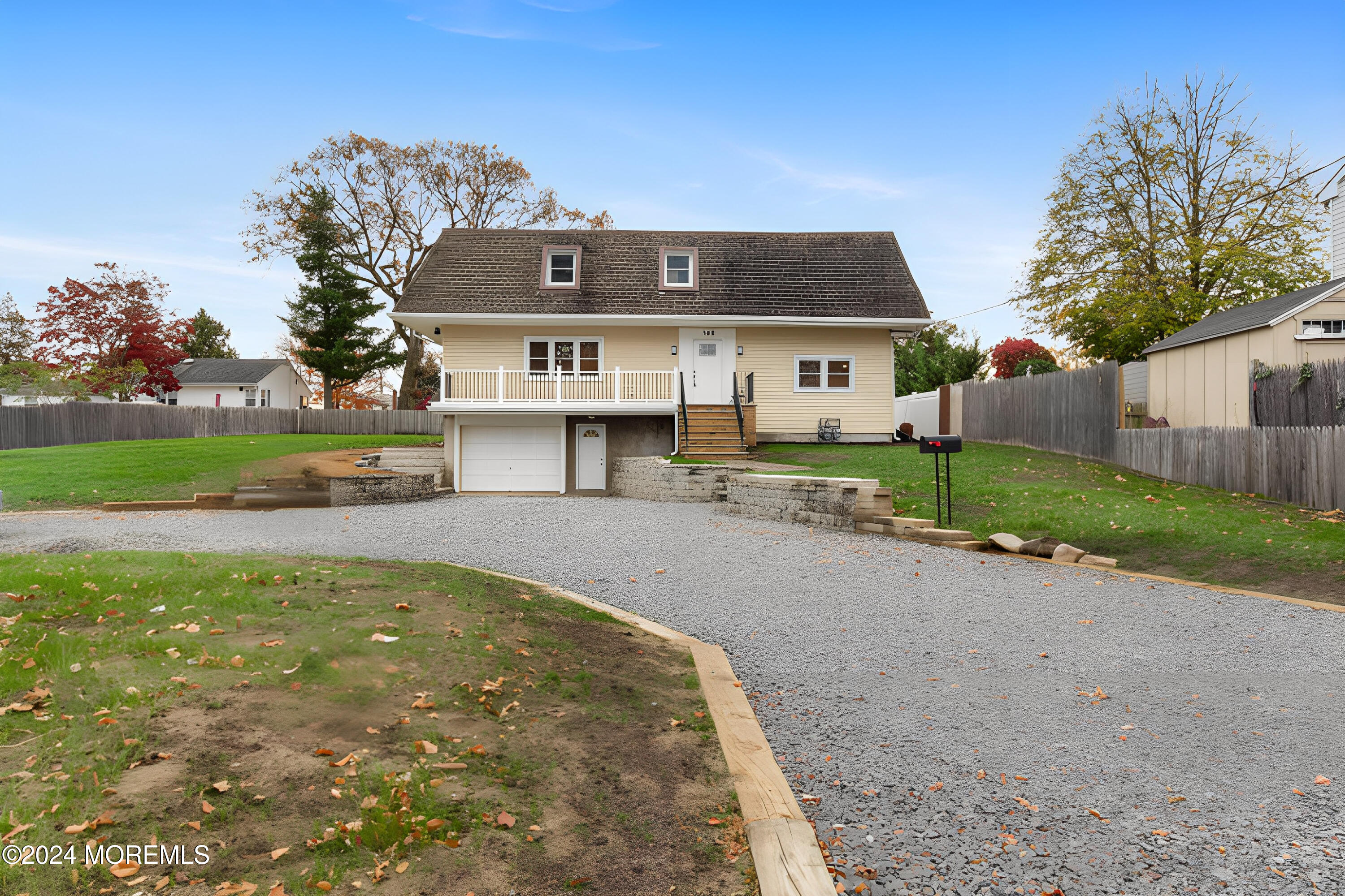 a view of a house with a yard and a large tree