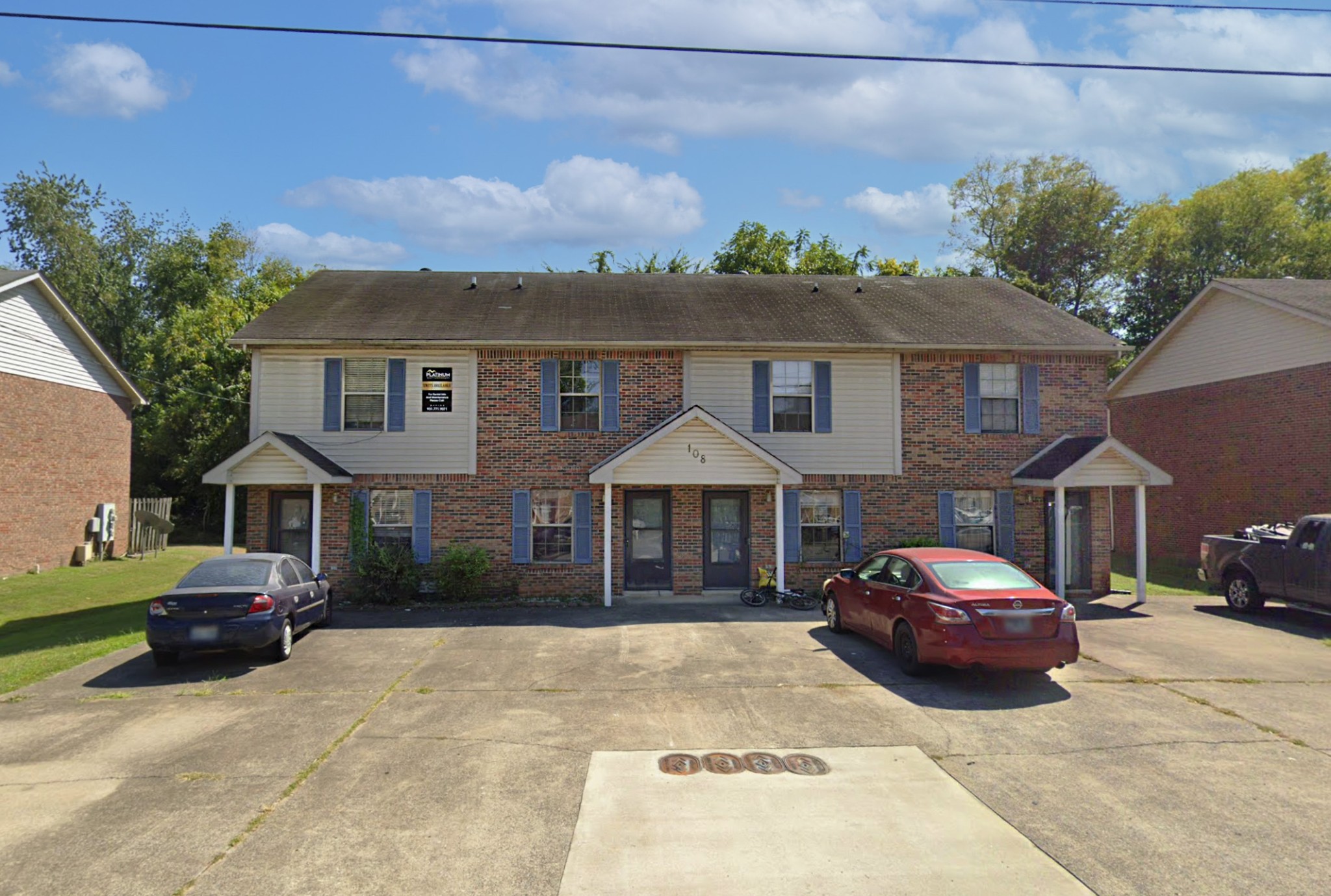 a front view of a house with a garden and parking