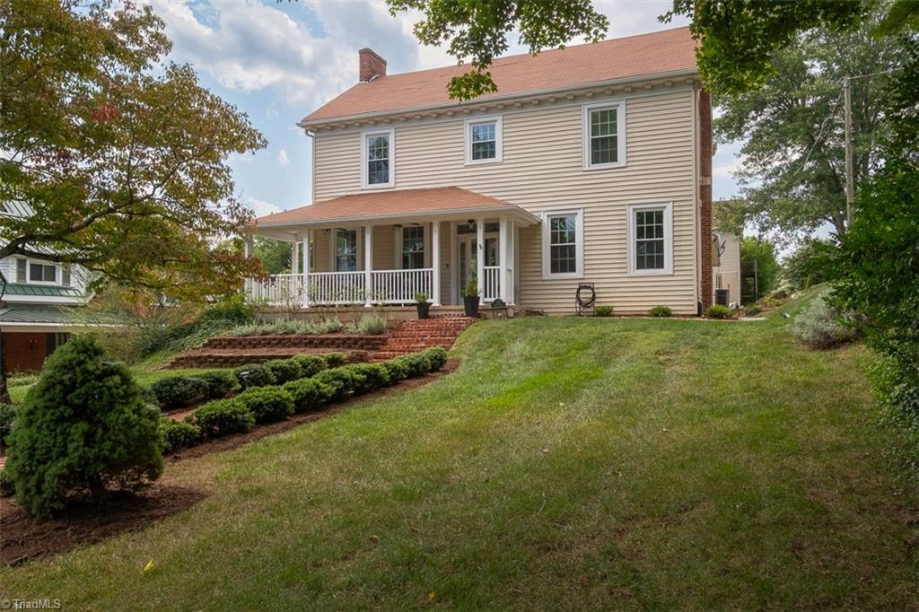 Standing on a terraced front lawn, this Colonial Revival-style home features original molding, trim, 10 ft ceilings.