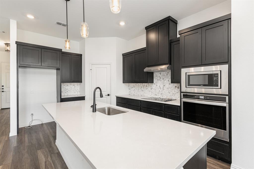 a kitchen with stainless steel appliances a microwave a sink and a refrigerator