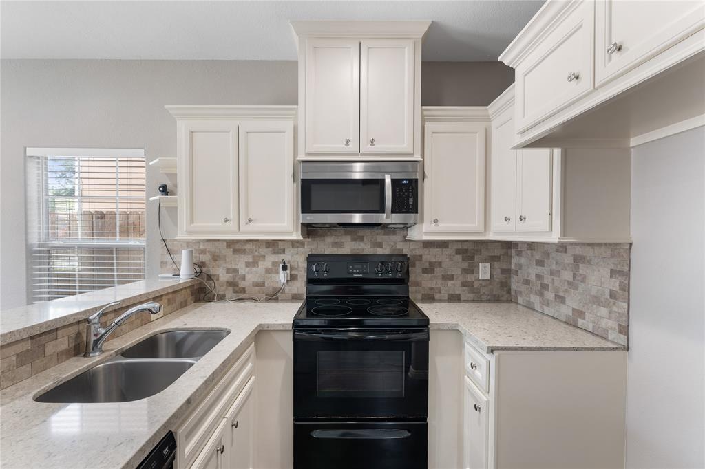 a kitchen with appliances a sink and cabinets