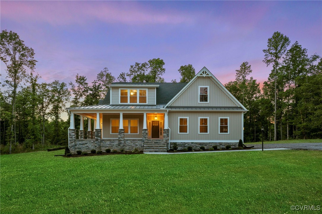 a front view of a house with a yard and trees