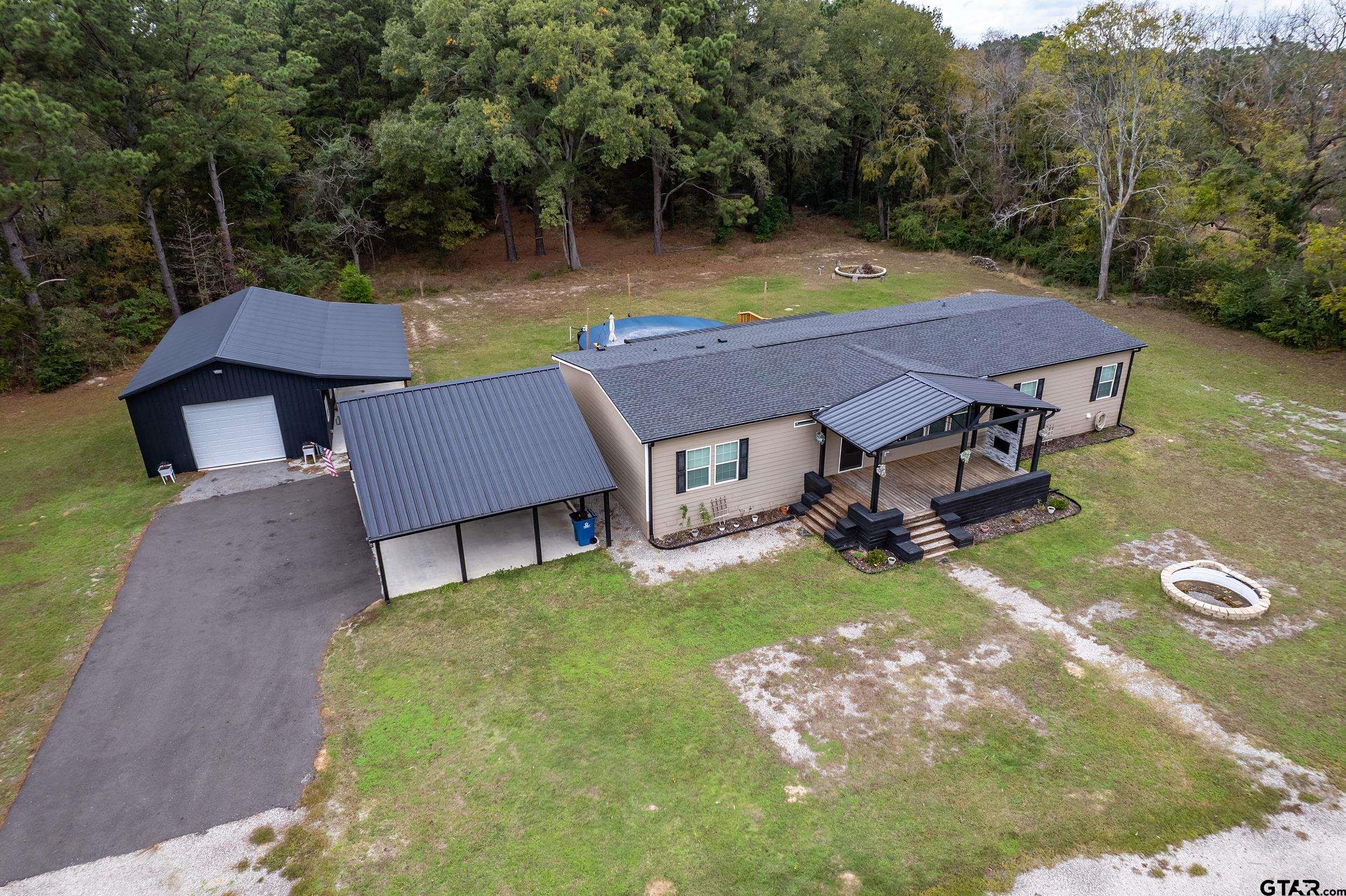 a aerial view of a house with swimming pool next to a big yard