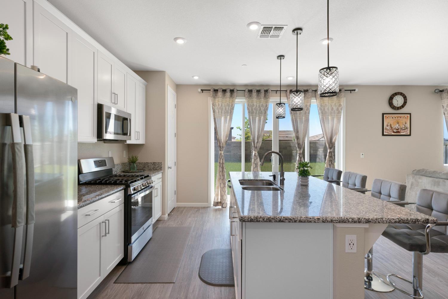 a kitchen with granite countertop kitchen island stainless steel appliances a table and chairs