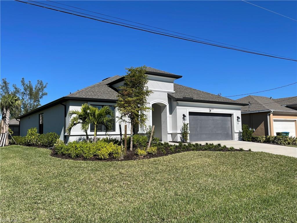 View of front facade with a garage and a front lawn