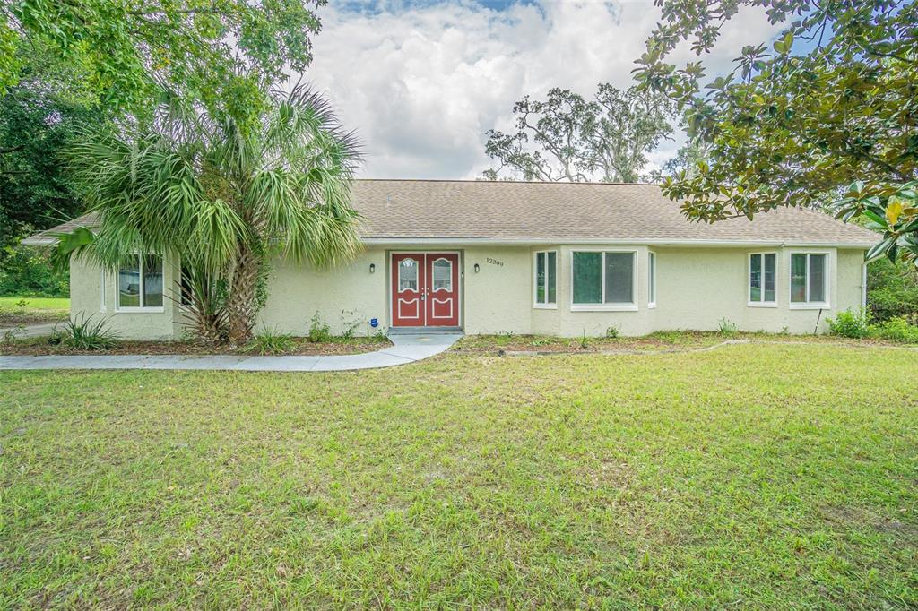 a front view of house with yard and trees around