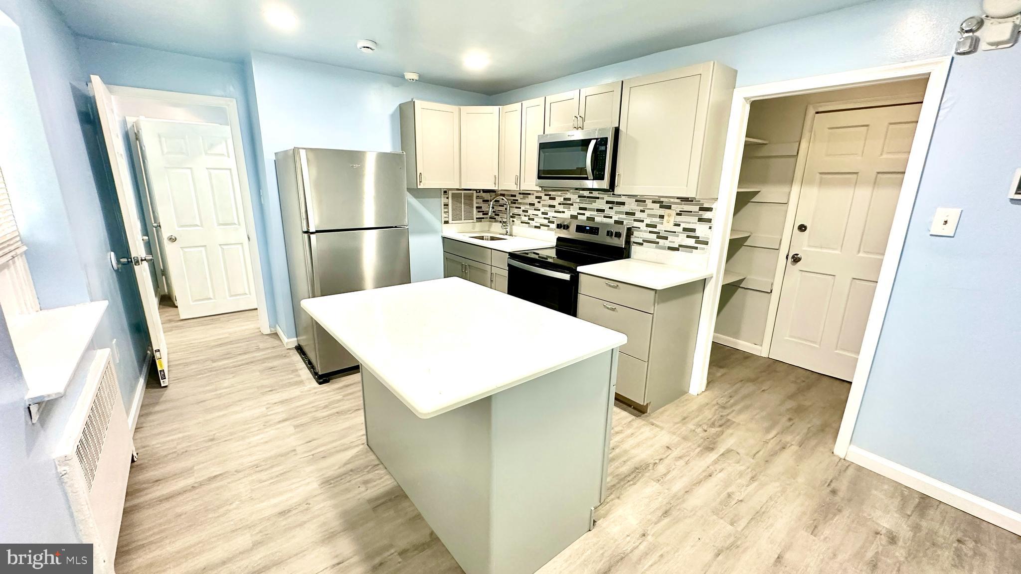 a kitchen with stainless steel appliances a refrigerator stove microwave and sink