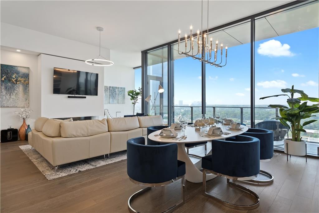 a living room with furniture a flat screen tv and kitchen view