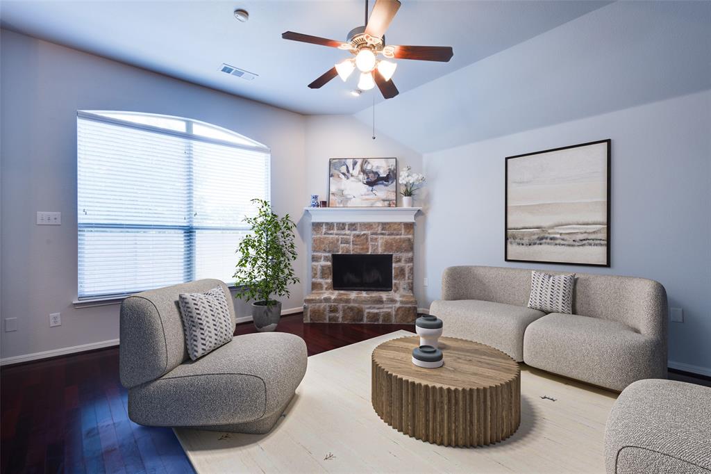 a living room with furniture a fireplace and a large window