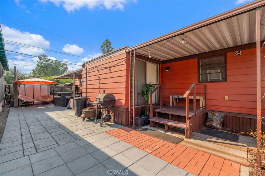 a backyard of a house with barbeque oven table and chairs