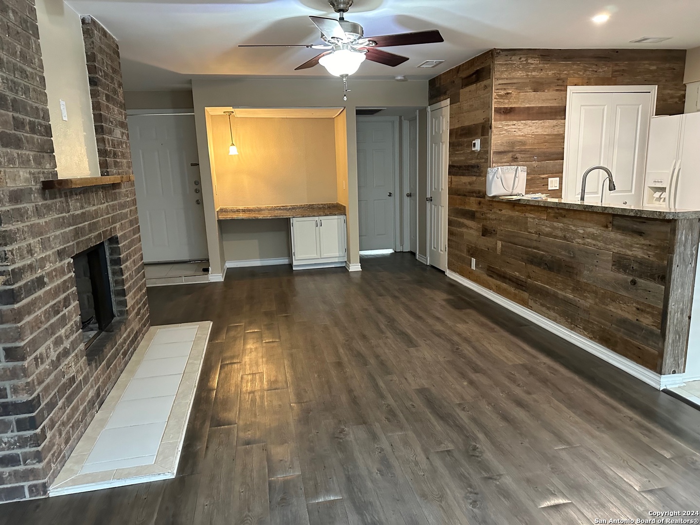 a view of a hallway with wooden floor and a fireplace