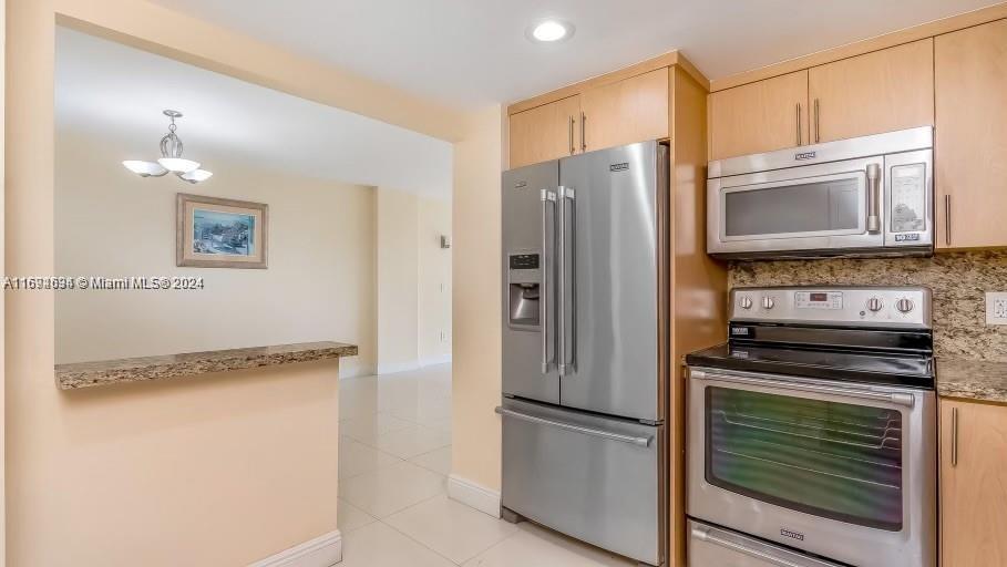 a kitchen with stainless steel appliances granite countertop a refrigerator and a stove top oven