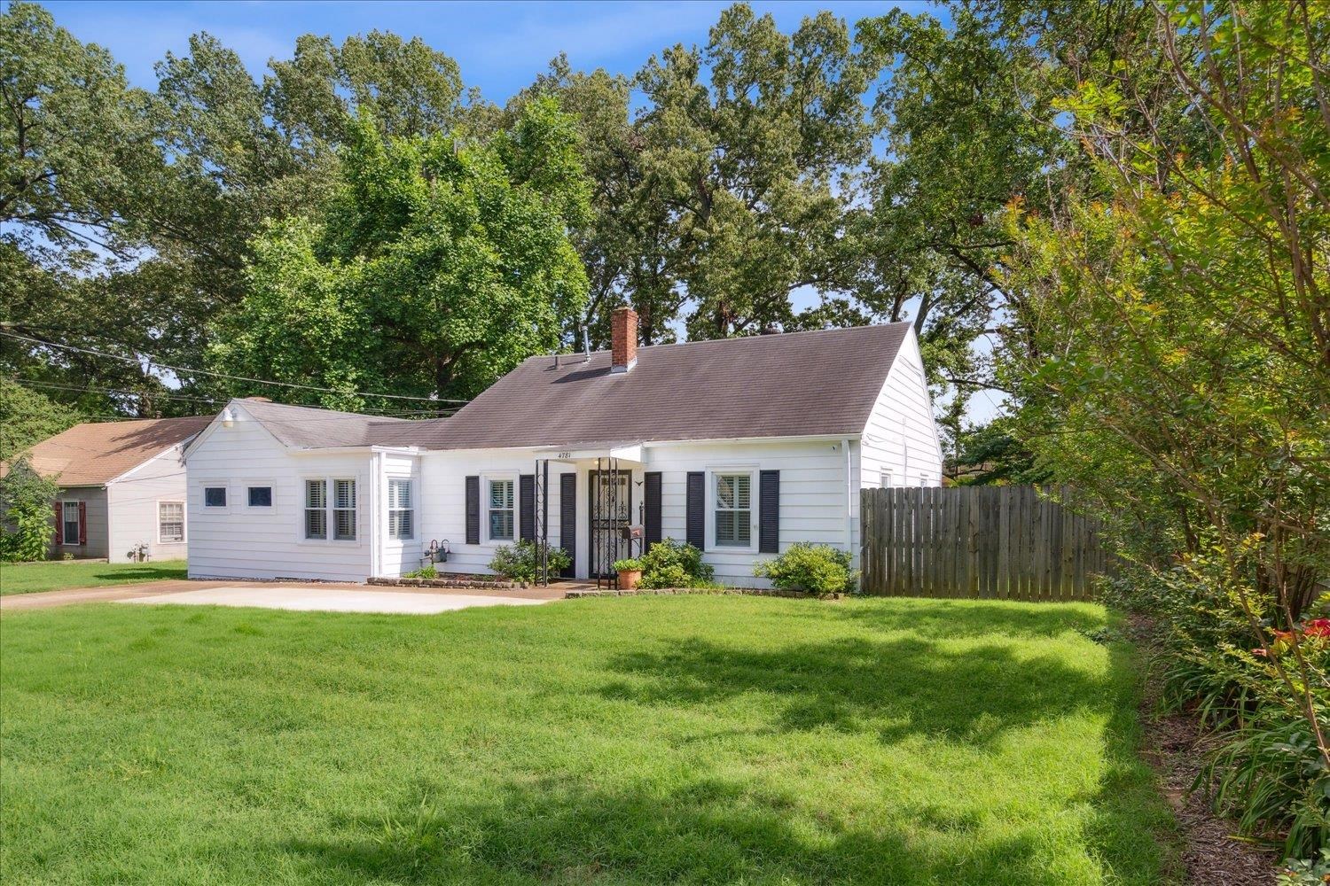 a view of a house with a big yard and large trees