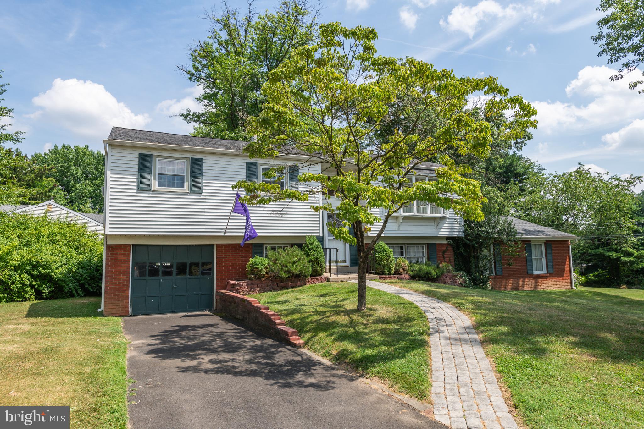 a front view of a house with a yard and trees