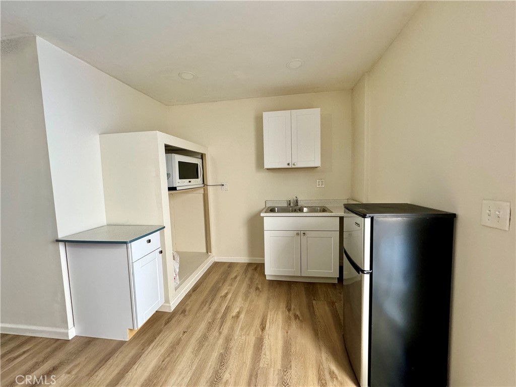 a view of a kitchen with a refrigerator cabinets and a wooden floor